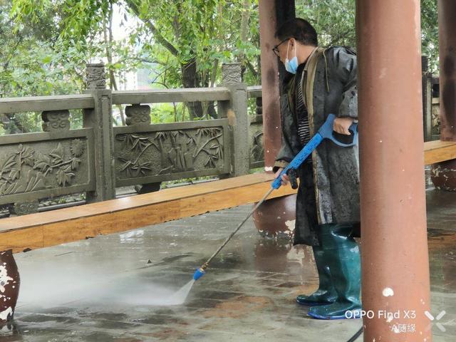 安岳紫竹公园环卫工人正在冲洗石板上的青苔